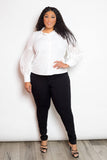 Plus-size model wearing a white blouse with punched sleeves and black pants, showcasing stylish and comfortable fashion.