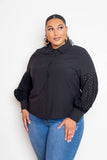 Plus size model in black blouse with punched sleeves, front view